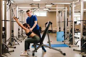 Spine rehabilitation with kinesiotherapy. Doctor helps his patient to relax tense back muscles and...