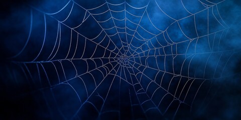 A spooky spiderweb against a dark blue background, perfect for Halloween posters, banners, or scary illustrations.