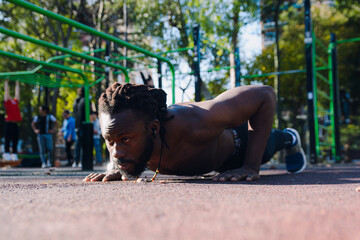 young black man doing push ups in the park