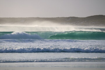 Cristal clear wave breaking on the beach