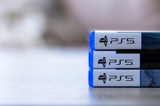 Brecht, Belgium - 3 october 2024: A frontal closeup portrait of 3 Playstation 5 or PS5 game cases stacked on top of each other, ready to be opened and played with some open space next to them.