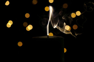 Smoke from an extinguished candle on a dark background with Christmas Lights Defocused Bokeh