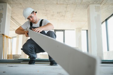 male construction worker wearing uniform Install gypsum ceiling inside the house and building