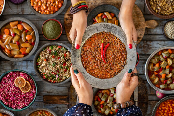 Hands of two women holding their meal plate named green lentil meal , kara şimşek 