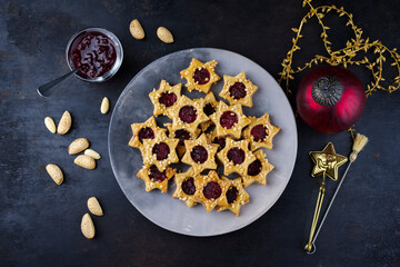 Homemade Christmas cookies biscuites Linzer augen, Spitzbuben with nuts and marmalade jam served as top view on a design plate