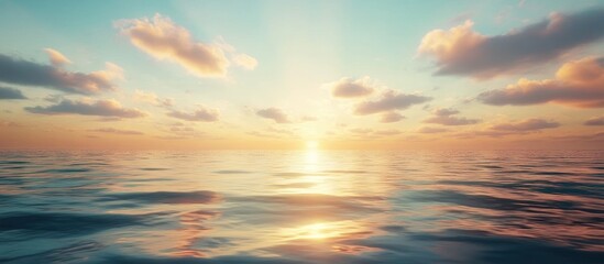 Fototapeta premium A scenic sunset over calm ocean water with clouds in the sky.
