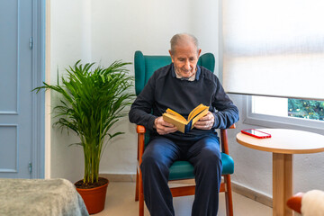 Senior man reading a book sitting alone in a geriatrics