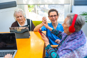 Senior women and nurse using technology in the geriatrics