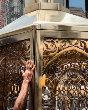 Cutout image of a person putting their hand on Maqaam-e-ibrahim