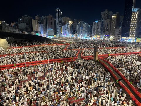 Crowd of people praying outdoors at Masjid al-Haram in Mecca province