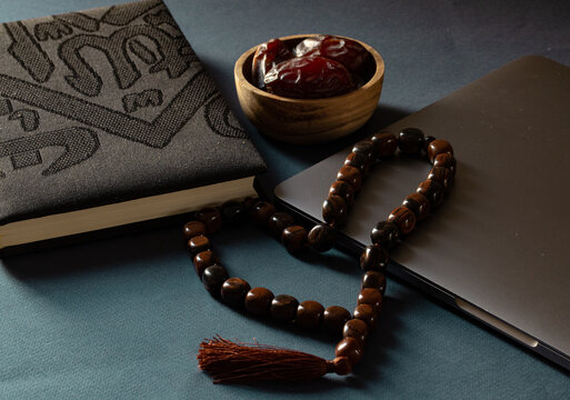 Display of a brown Misbaha, a cup of dates of the Quran