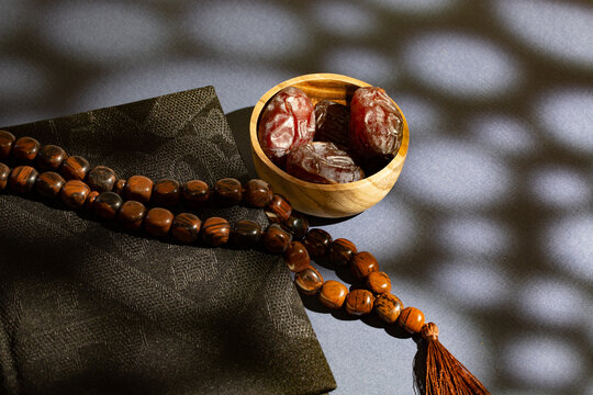 Display of a brown Misbaha, a cup of dates of the Quran
