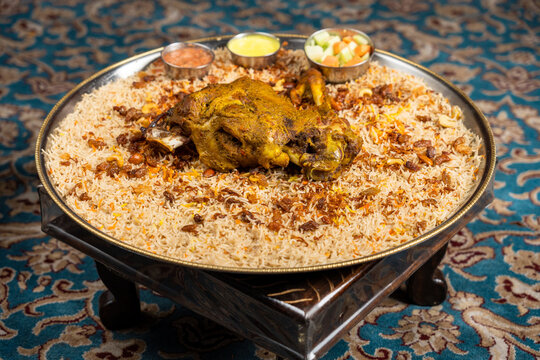 Flat lay of mutton mandi with vegetables and sauces