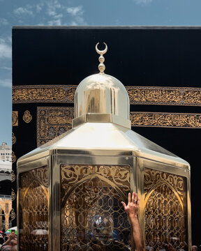 People putting their hand on Maqaam-e-ibrahim