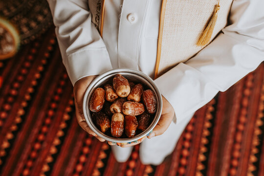 Person holding bowl of dates