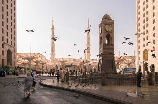 People walking in plaza near Al Masjid an Nabawi beside pigeons