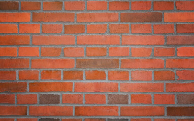 Classic red brick wall with an even, horizontal pattern. The rich red and orange hues of the bricks contrast against the light gray mortar, creating a timeless and structured design.