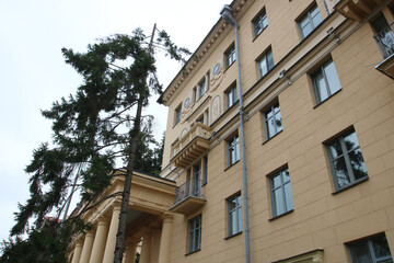 Obraz premium A large building with a balcony and a tall tree in front