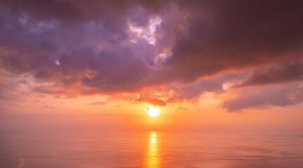 Beautiful sunset cloudy sky with sunlight from aerial top view, toning. Drone photo above clouds