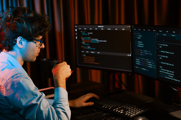 Working IT developer concentrating online software while drinking coffee on surrounded by coding...