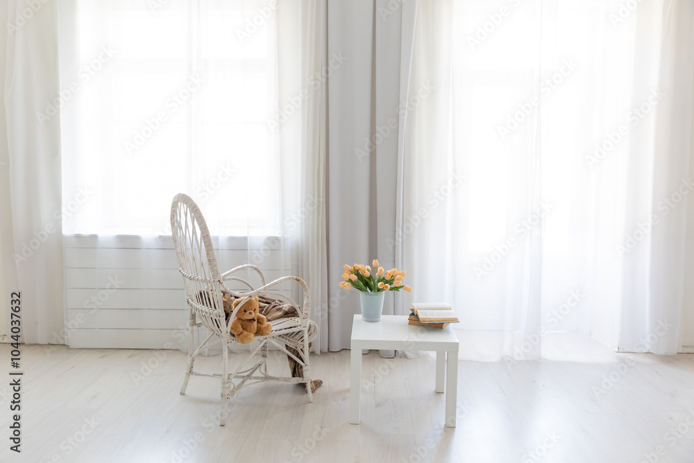 Poster Bright armchair with table by the window in the interior of a white room