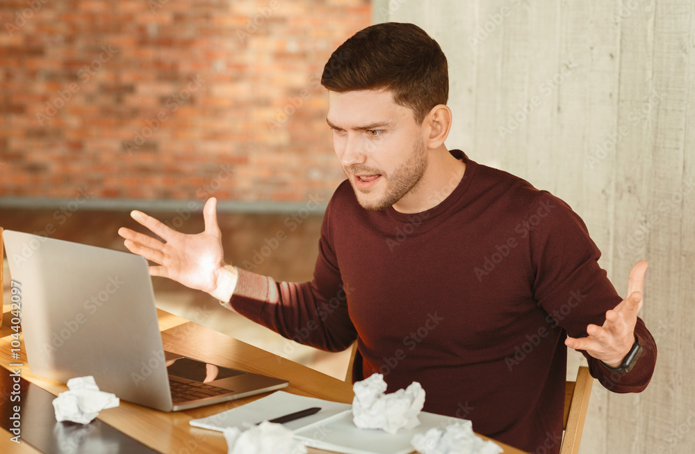 Poster Angry Employee Guy At Laptop Gesturing With Hands Having Problem With Computer Sitting In Modern Office. Selective Focus