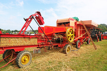Fototapeta premium Vintage baler working in a field 
