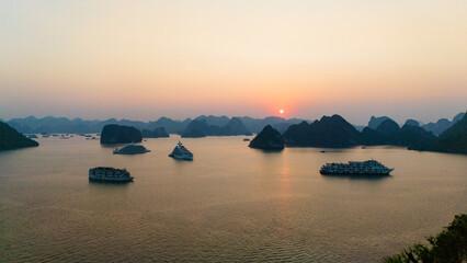 Aerial view of the Hạ Long Bay, Halong Bay is a UNESCO World Heritage Site and popular travel destination in Quảng Ninh province, Vietnam. Cruise ships and islands alternate in the bay. Sunset