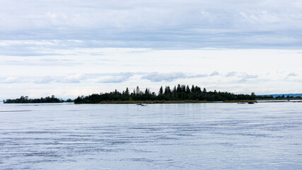 A stunning Knik River landscape near Anchorage, Alaska, featuring small land islands scattered...