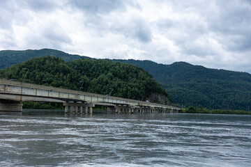 Fototapeta premium A scenic bridge stretches over the Knik River near Palmer, Alaska, offering a vital connection to Anchorage with breathtaking views of surrounding mountains and wilderness.