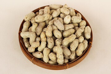 Unpeeled peanuts in a container isolated on a white background. close up of salted peanuts.