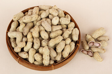 unpeeled peanuts in a container isolated on a white background. close up of salted shell peanuts.