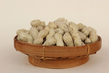 unpeeled peanuts in a container isolated on a white background. close up of salted shell peanuts.