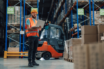Warehouse worker holding laptop checking inventory in distribution center © Zamrznuti tonovi