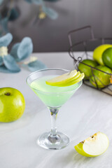Green apple martini cocktail standing on white tablecloth