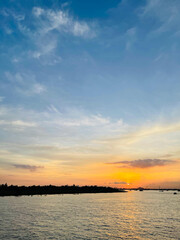 Obraz premium A sunset view of a river and a river with clouds in the sky