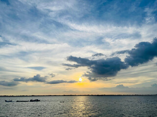 A sunset view of a river and a river with clouds in the sky