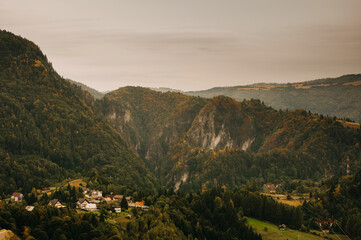 The stunning view showcases majestic mountains and a tranquil village nestled within natures embrace
