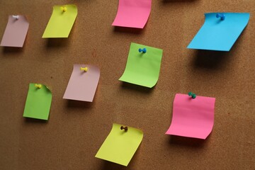 Colorful paper notes pinned to cork board