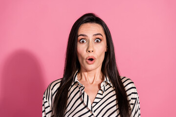 Fototapeta premium Surprised young woman in striped shirt against pink background showing shocked expression