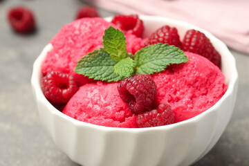 Delicious raspberry sorbet, fresh berries and mint in bowl on gray table, closeup