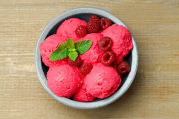Delicious raspberry sorbet, fresh berries and mint in bowl on wooden table, top view