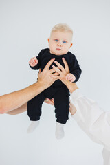 Baby boy close-up in the hands of mom and dad. Parents hold their son in their hands.