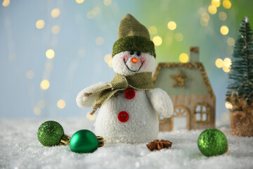 Cute decorative snowman and other Christmas decor on artificial snow