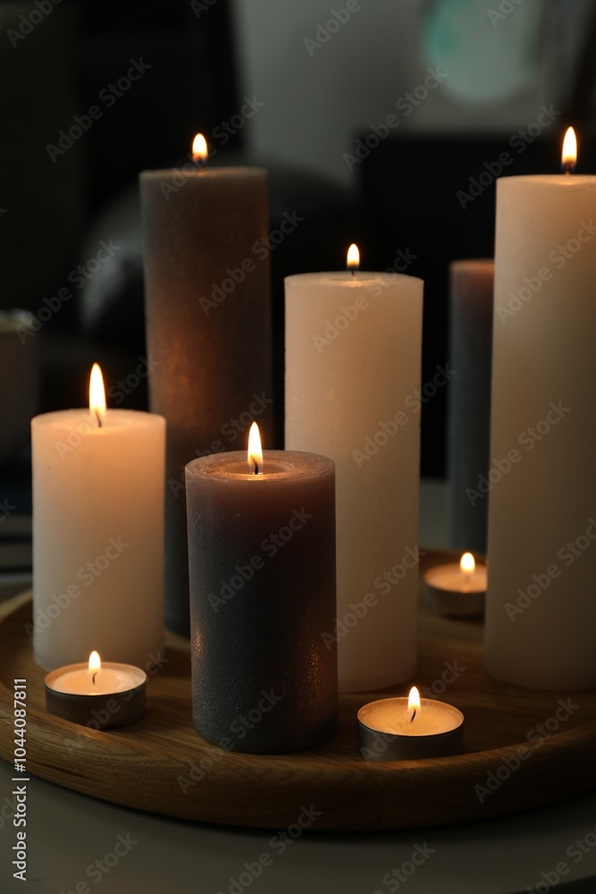 Poster Beautiful burning candles on table indoors, closeup