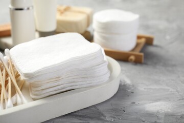 Clean cotton pads and swabs on grey table, closeup