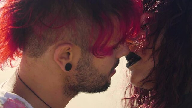 Extreme close up shot of a Punk guy and Goth girl who are about to kiss in the middle of a vast desert but stop at the last moment.
