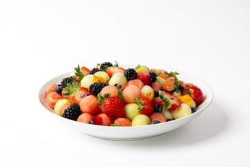 Large bowl of fresh fruit salad with melon balls and strawberries
