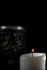 Lighted candles, scene with various objects and recently extinguished candles. Selective focus.