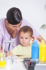 Obraz premium A woman and a child are sitting at a desk with a variety of art supplies for craft project